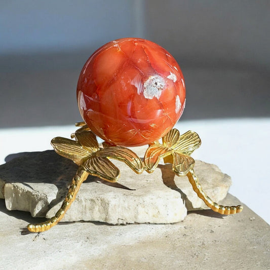 Carnelian crystal sphere on a golden stand