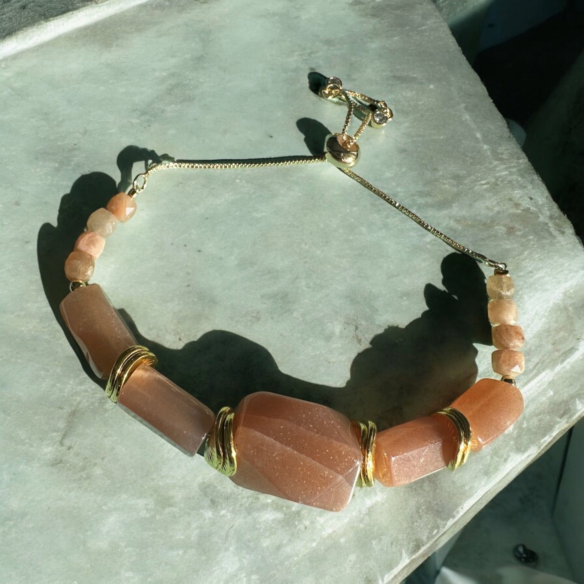 Sun stone crystal bracelet on a concrete