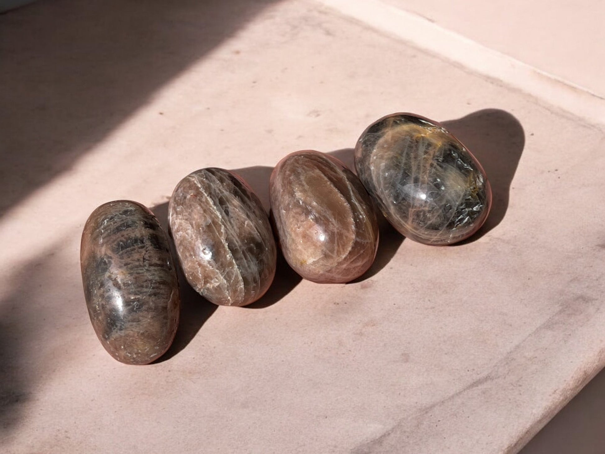 Black moonstone tumbled crystals on concrete