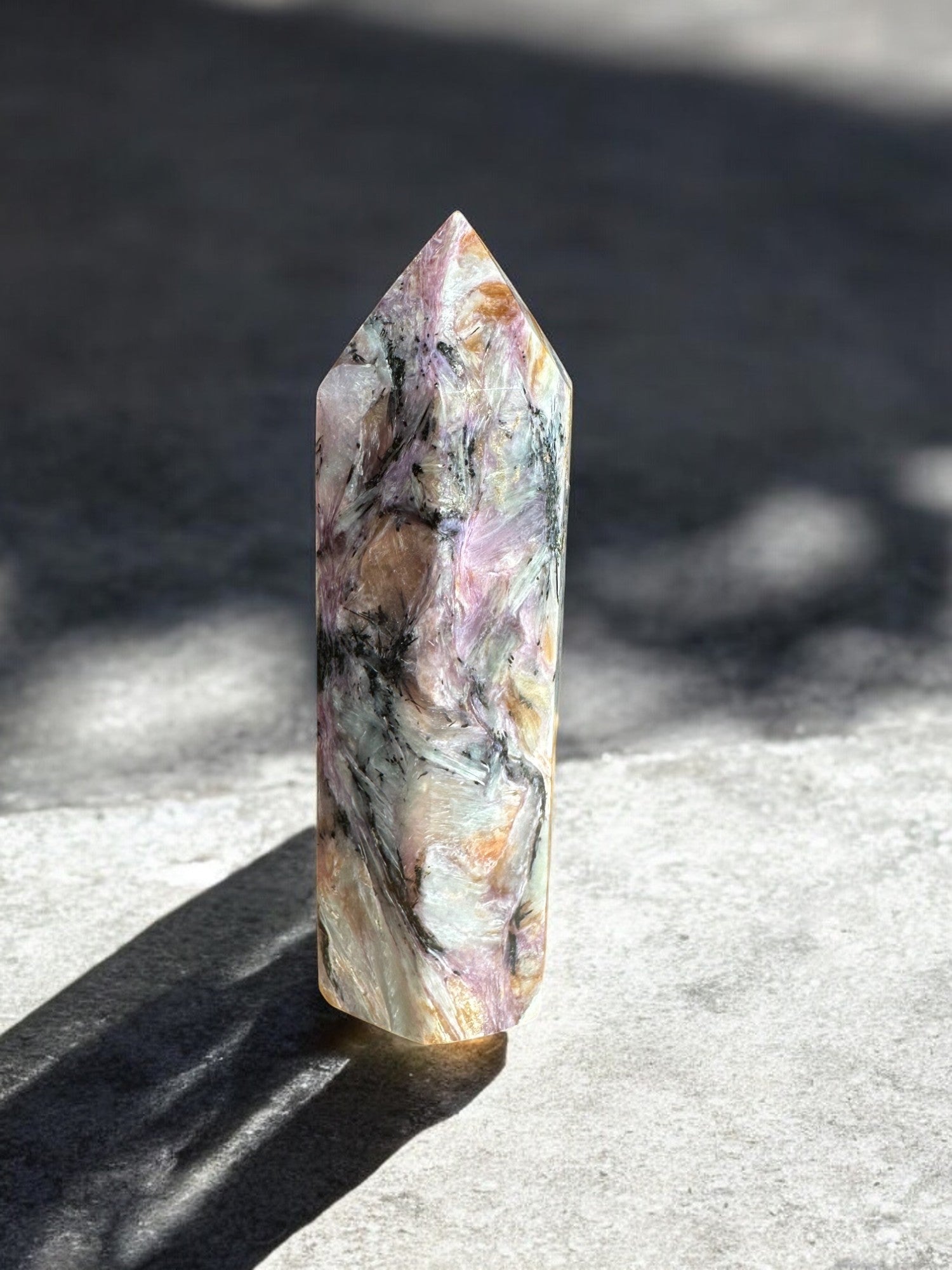 Charoite crystal tower on a concrete plate back view