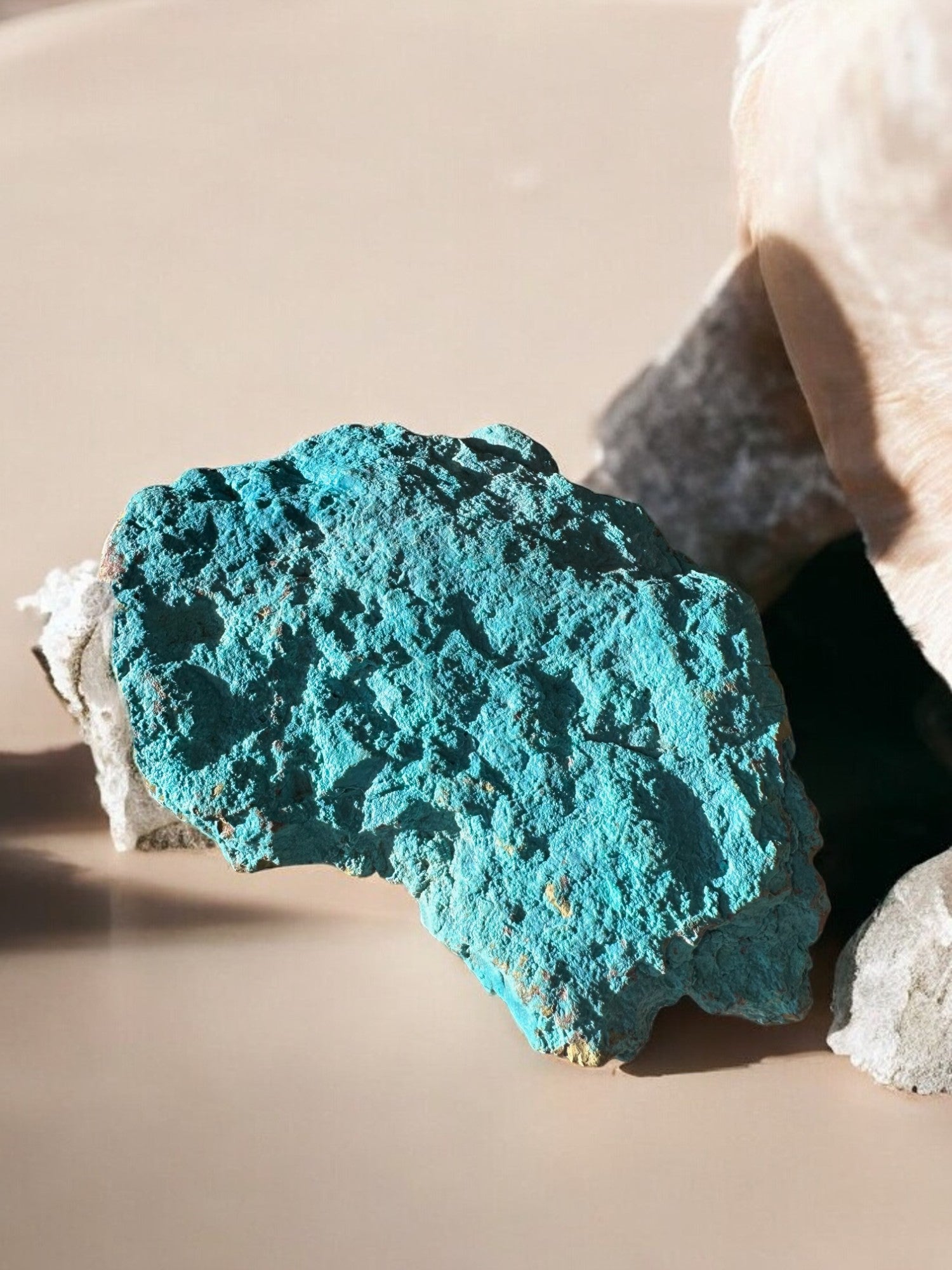 chrysocolla raw crystal leaning on rocks