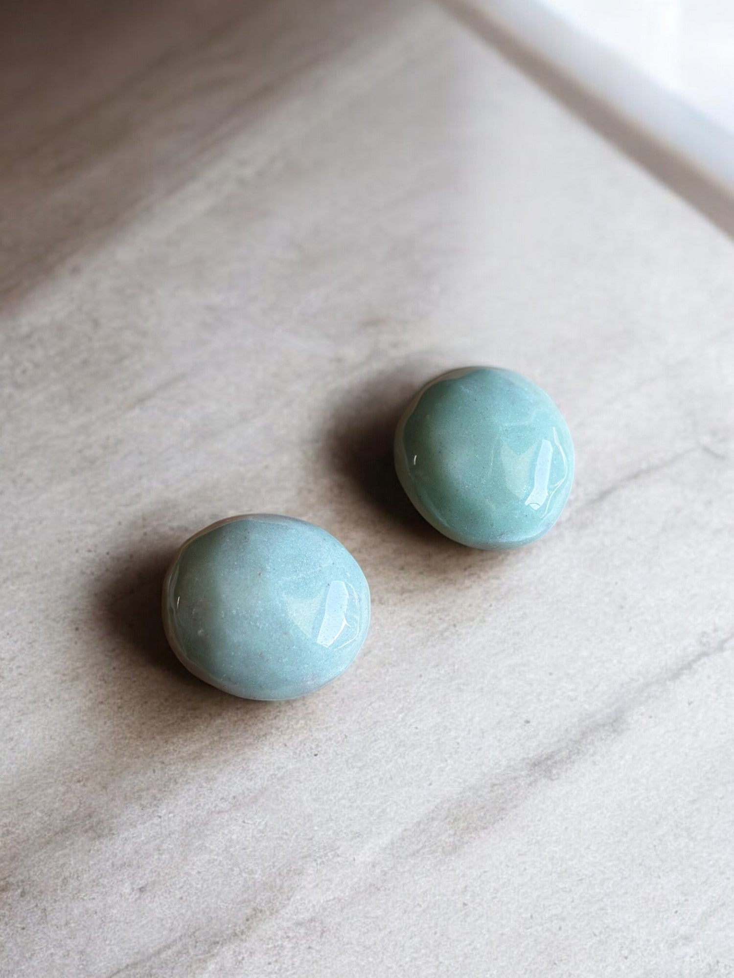 Green aventurine palm stones on a concrete